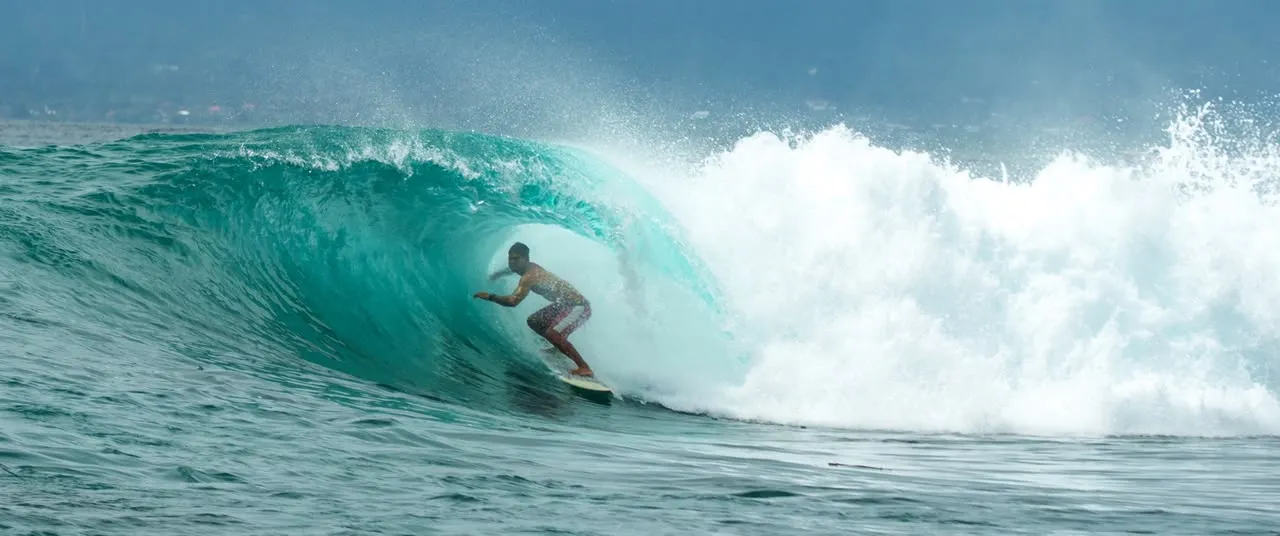 Loxy deep inside a clean turquoise barrel at Nusa Lembongan