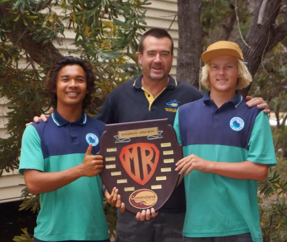 Loxy and a teammate holding the MR Shield open boys trophy with their coach between them