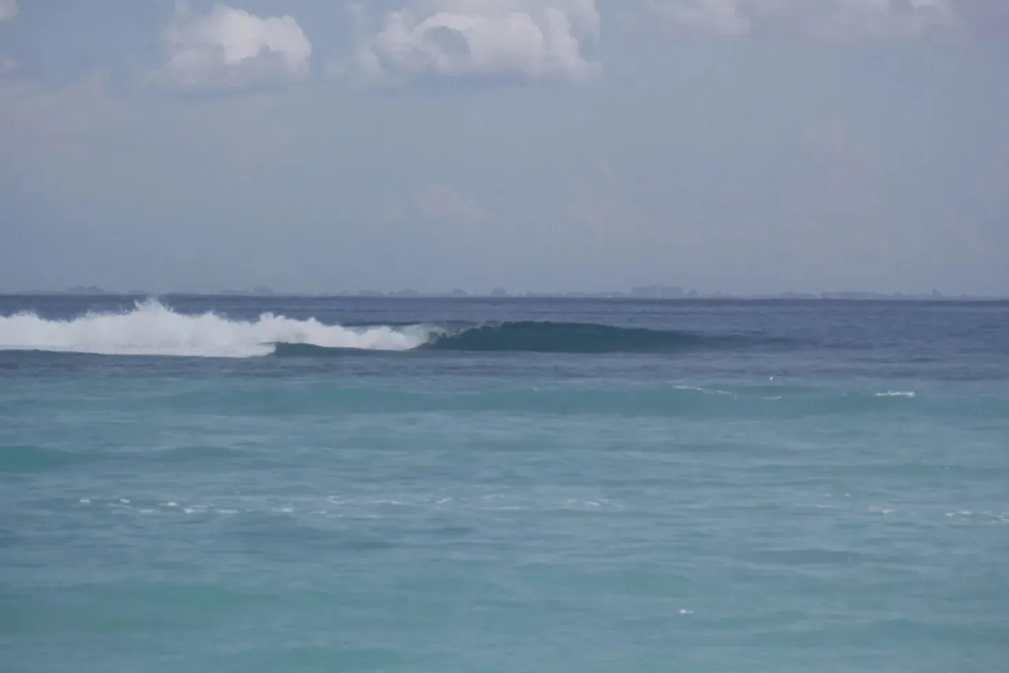 A clean, empty wave peeling over the reef at Razors, Nusa Lembongan, with glassy turquoise water