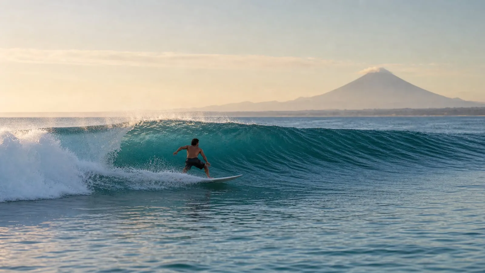 Clean head-high right-hander at Shipwrecks with offshore spray and a surfer mid bottom-turn